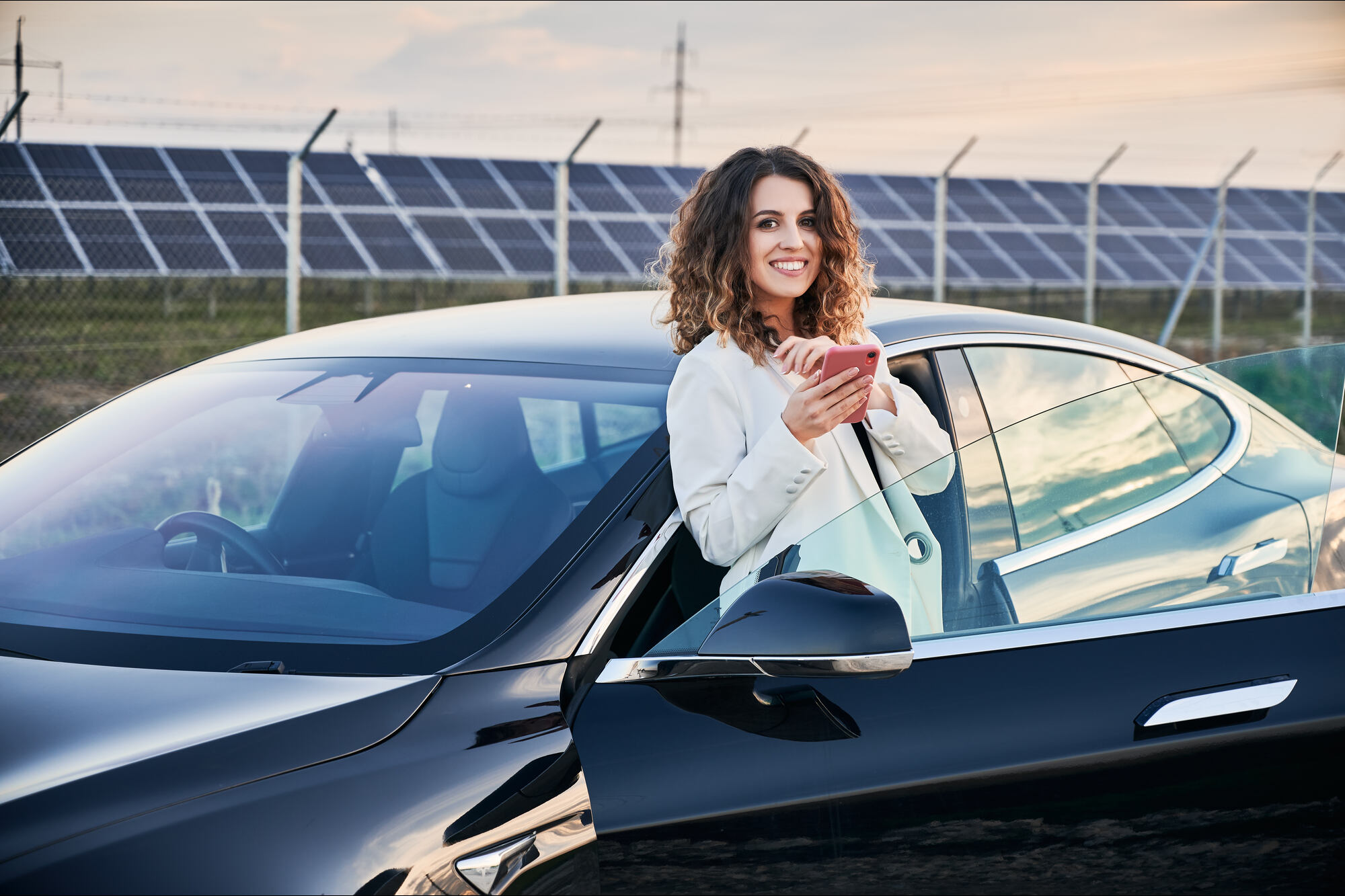 Woman stood next to a Tesla car
