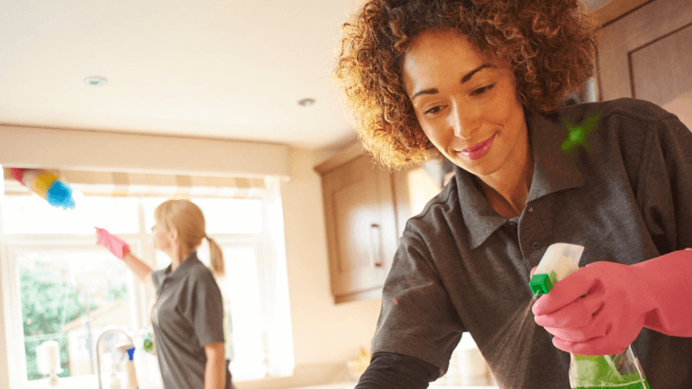 Professional cleaners working in a modern kitchen, wiping surfaces and cleaning windows — ideal for articles about Cleaner Insurance and business liability protection.