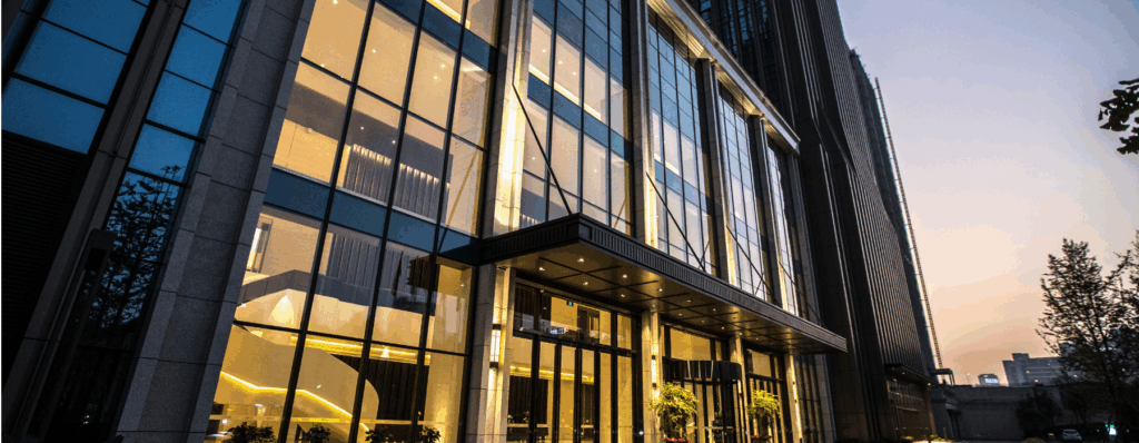 Modern glass-fronted commercial property at dusk, ideal for articles about Commercial Property Insurance for UK landlords and building owners.