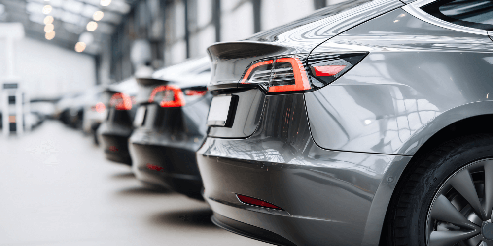 Cars lined up inside an indoor showroom or storage facility, representing insured motor stock