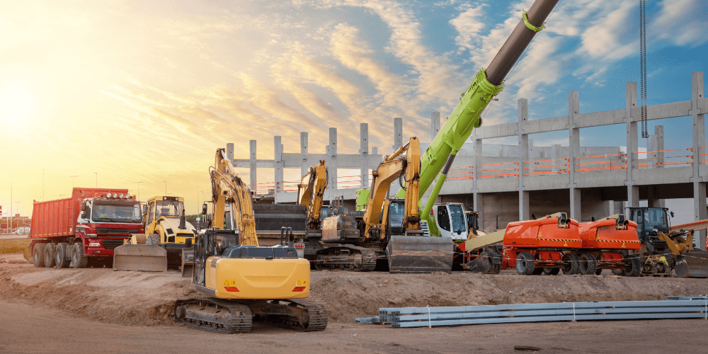 Active construction site with cranes, excavators and heavy machinery, representing insured construction plant