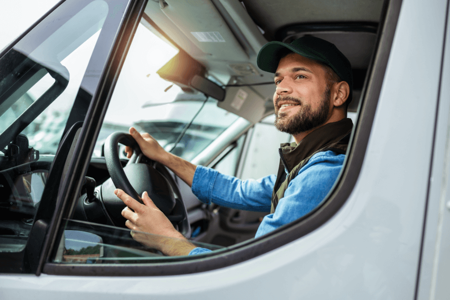 Courier van driver seated at the wheel, representing insured delivery and van driving