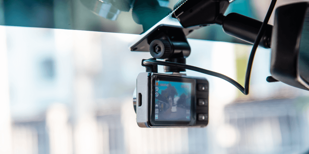 Dashboard camera mounted on a car windscreen, recording the road ahead for driving safety and insurance evidence