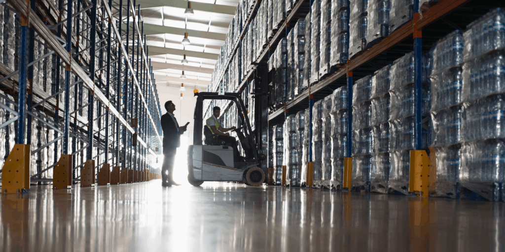 Warehouse forklift carrying out insured materials handling between high-bay storage racks