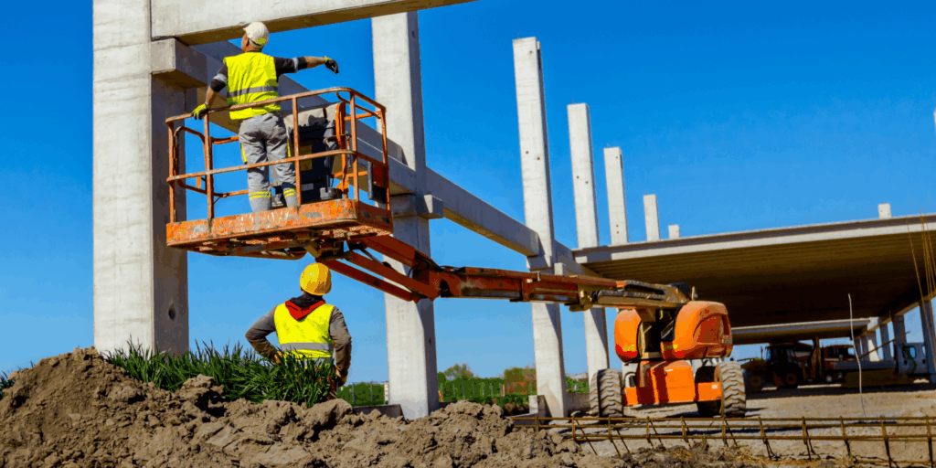 Construction workers using insured mobile elevated work platform on building site