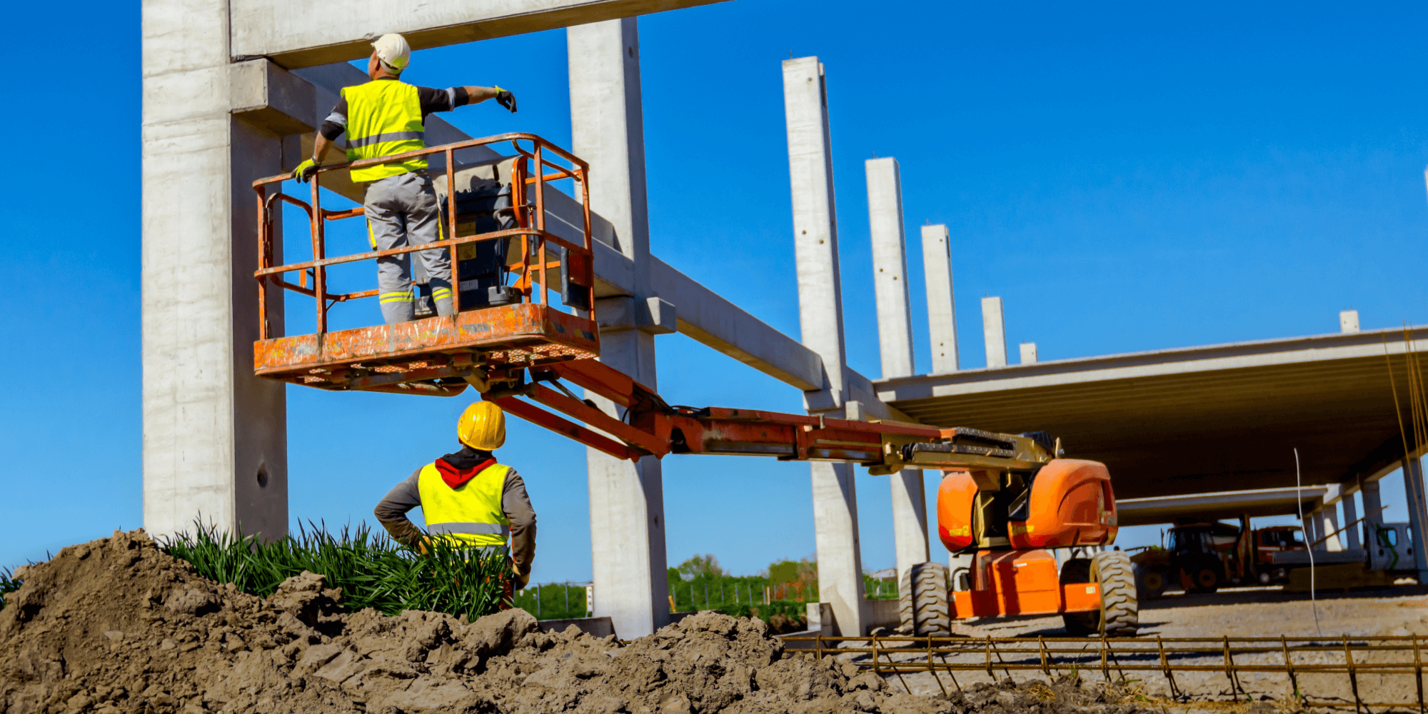 Construction workers using insured mobile elevated work platform on building site