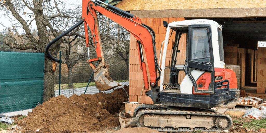 Mini excavator used for insured groundwork and excavation at a residential construction site