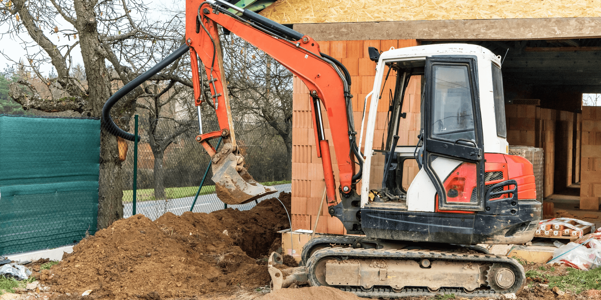 Mini excavator used for insured groundwork and excavation at a residential construction site