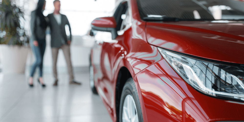 people in a car showroom buying a new car